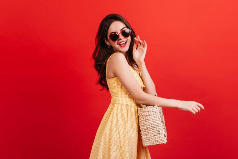 Female model wearing heart shaped glasses wicker bag