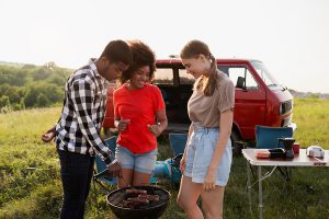 Medium shot friends preparing barbecue