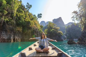 A beautiful girl is sitting in the boat at sea